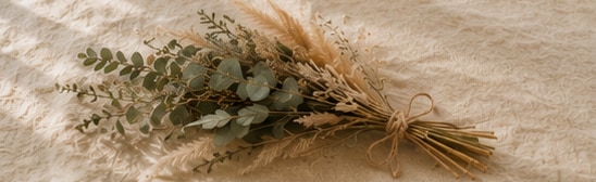 A small dried bouquet of botanicals tied with twine on linen
